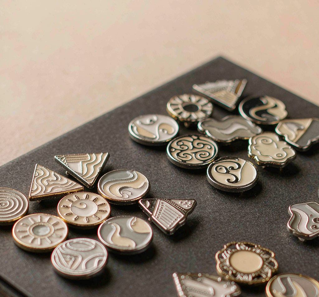 Hard enamel pins and metal brooches in assorted shapes