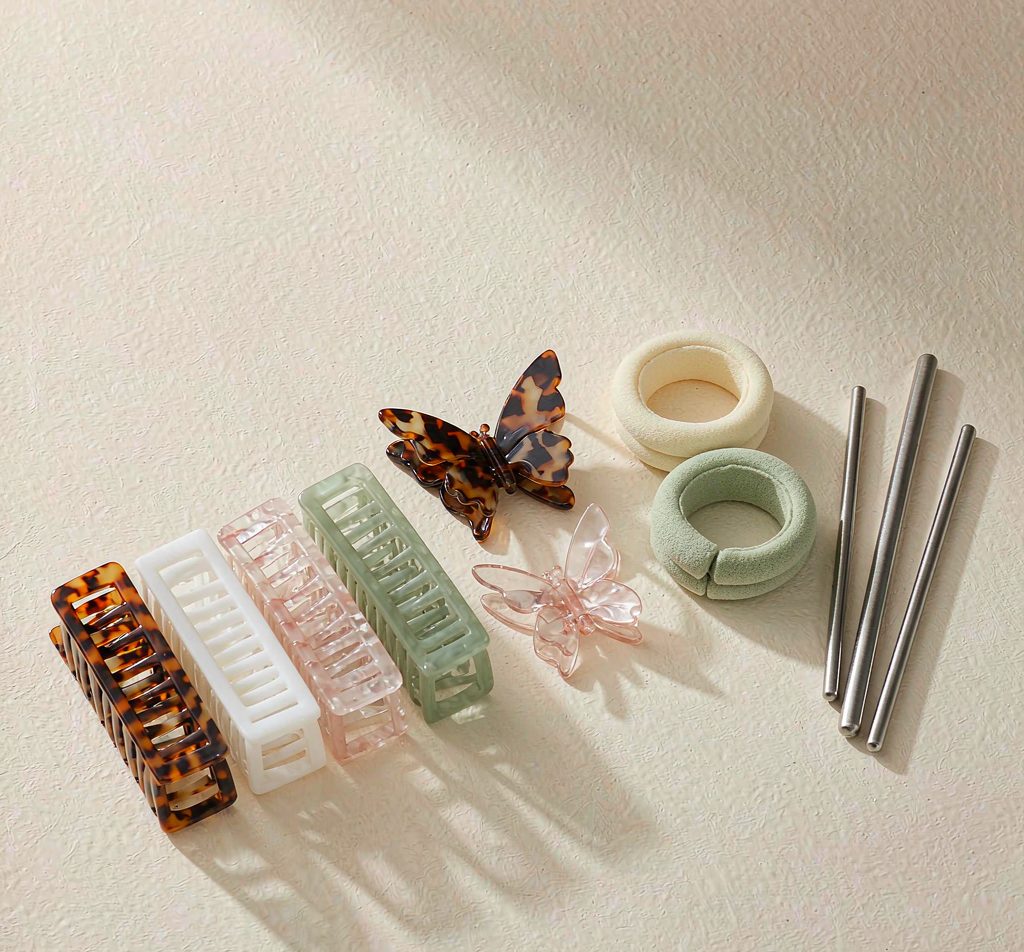 Acetate claw clips, fabric head hoops and fashion hairpins arranged in a row
